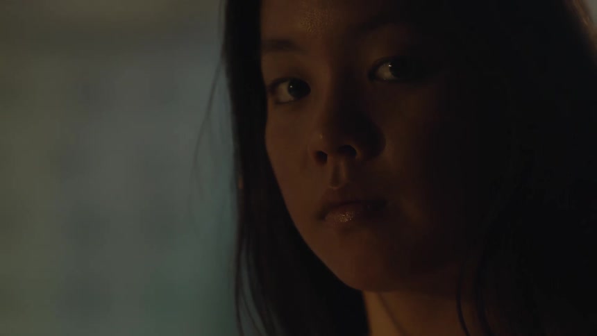 The face of a young woman with sunlight on her face and she is looking straight ahead