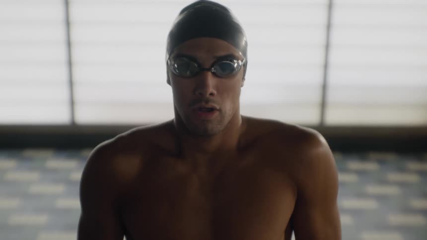 A swimmer wearing goggles and a cap prepares to swim