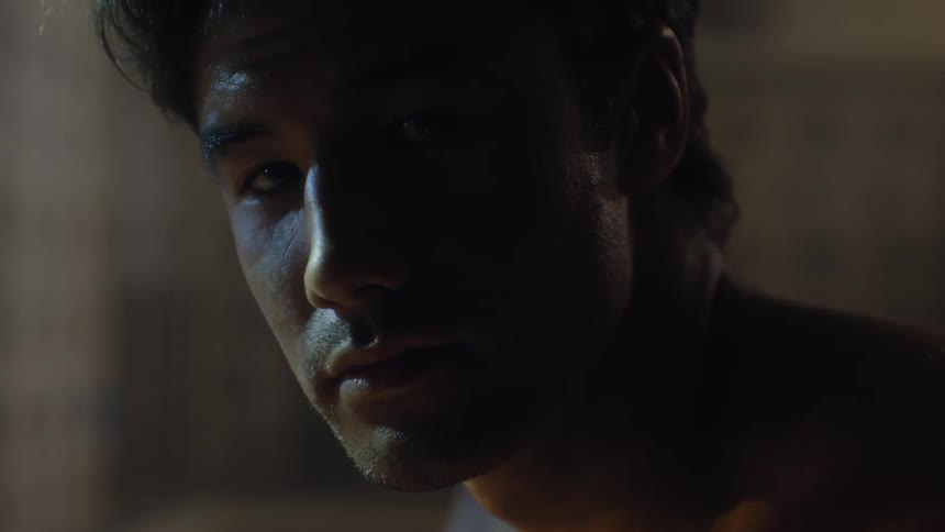 Portrait of a staring man shirtless in a locker room
