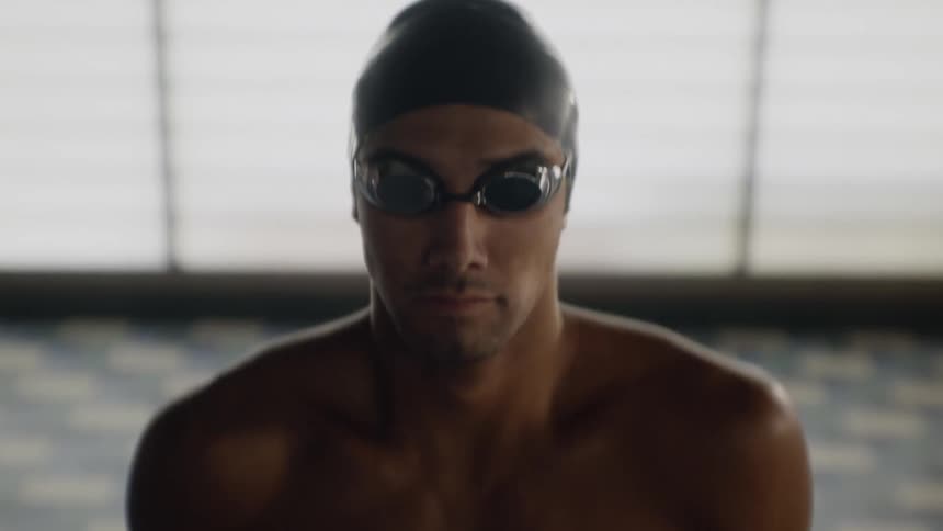 Man with swimming cap and goggles warming up