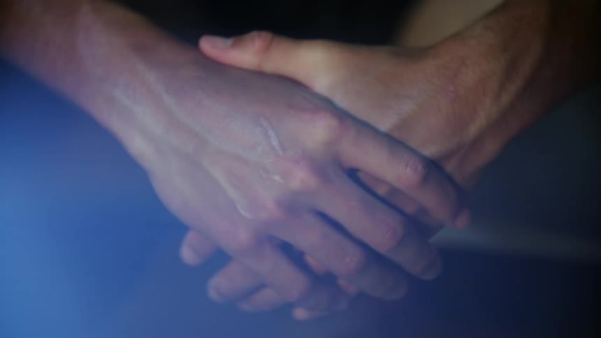 Mans hands clasped together