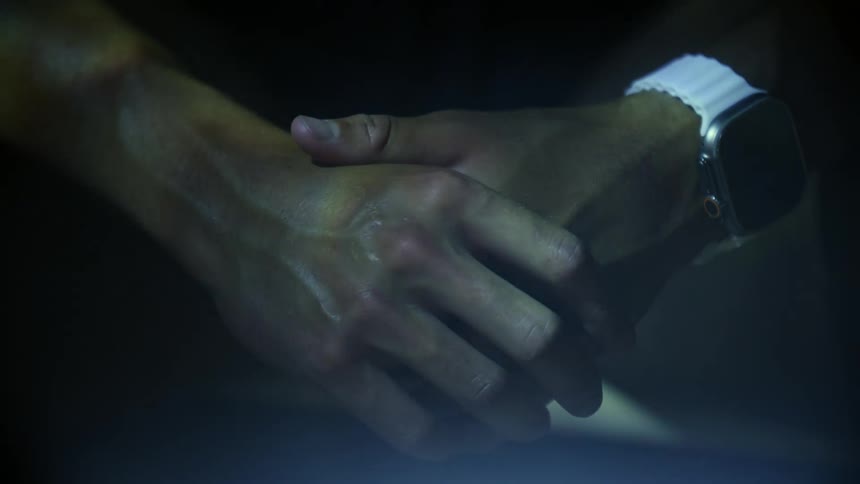 Close up of a persons clasped hands with water reflection