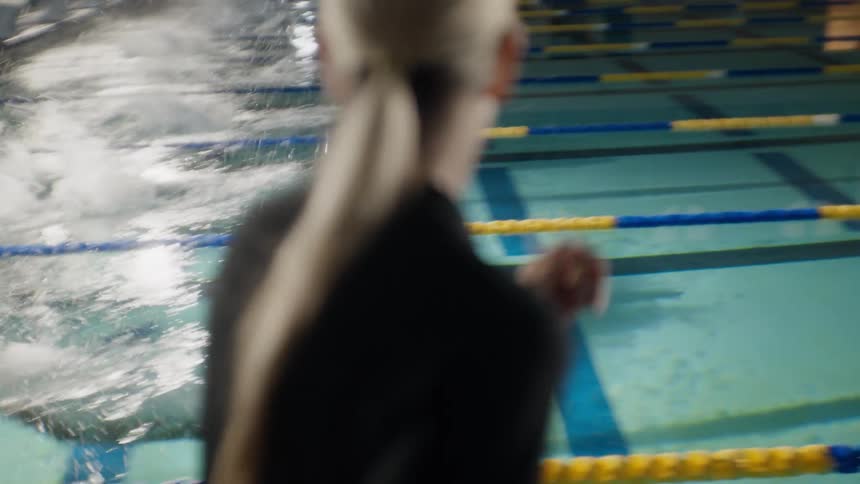 Instructor talking to students who jump into the pool and start swimming