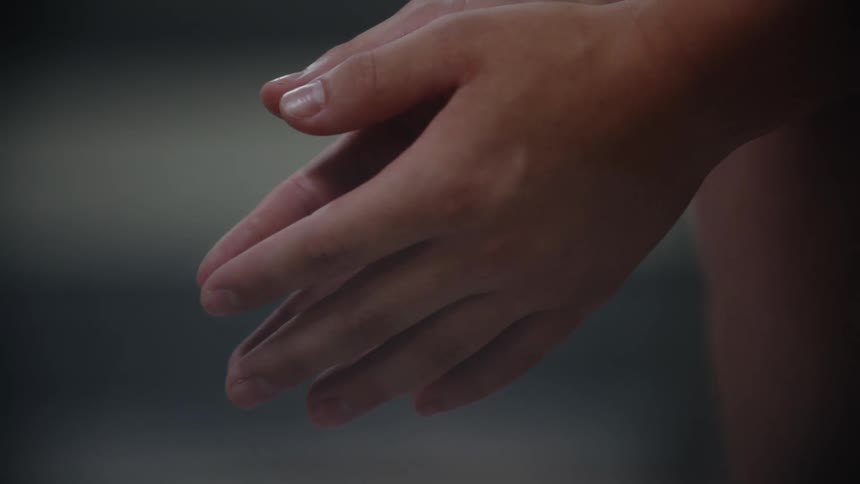 Closeup of two hands gently overlapping with fingers extended