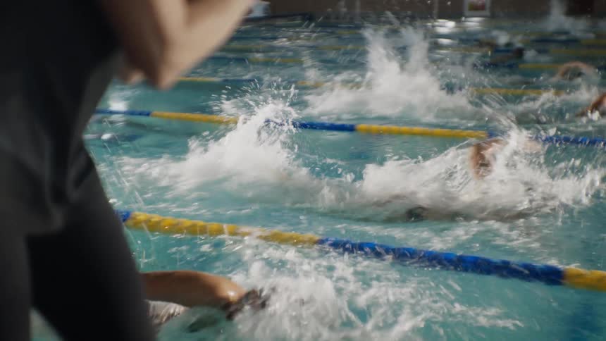 Swimmers are racing in the pool water