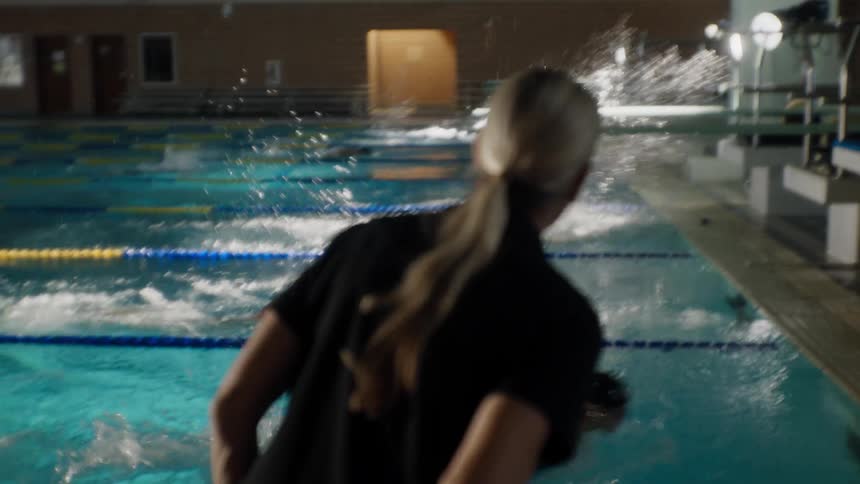 Female instructor outside the pool accompanying the swimmers