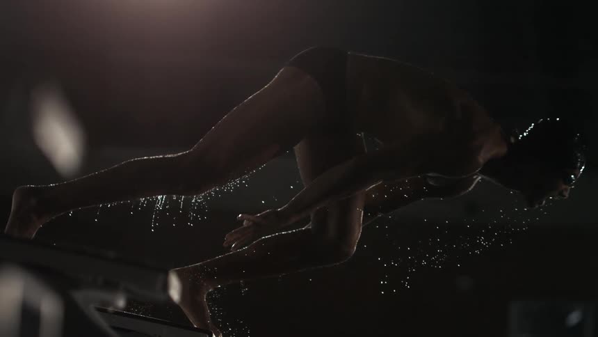 A swimmer dives into the pool