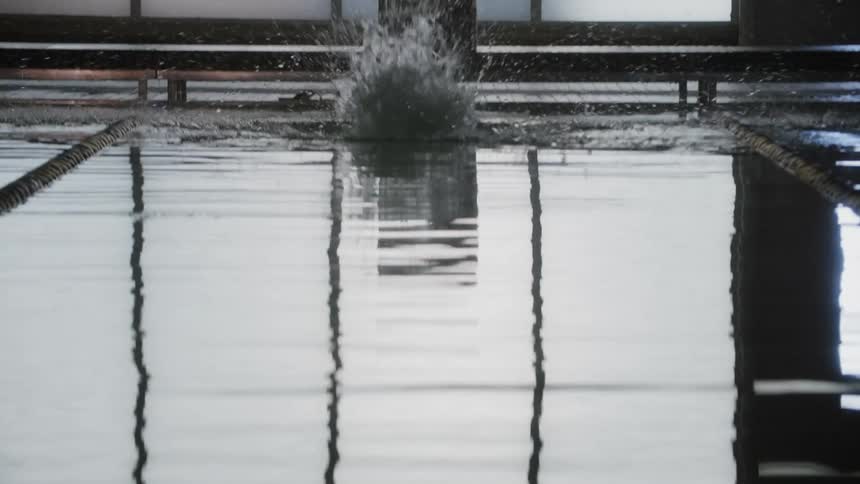 Swimmer in position at the starting point jumping into the pool lane