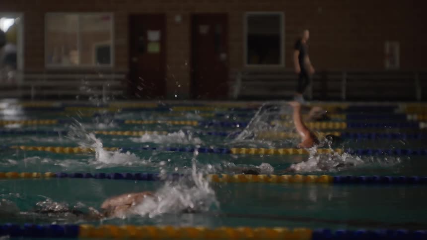 Swimmers race in the water against each other