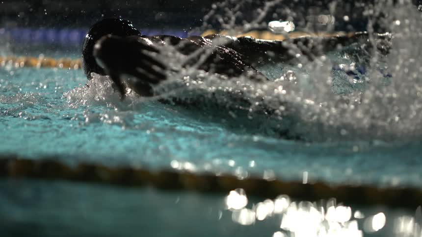 Swimmer in action at night with water splashing around him