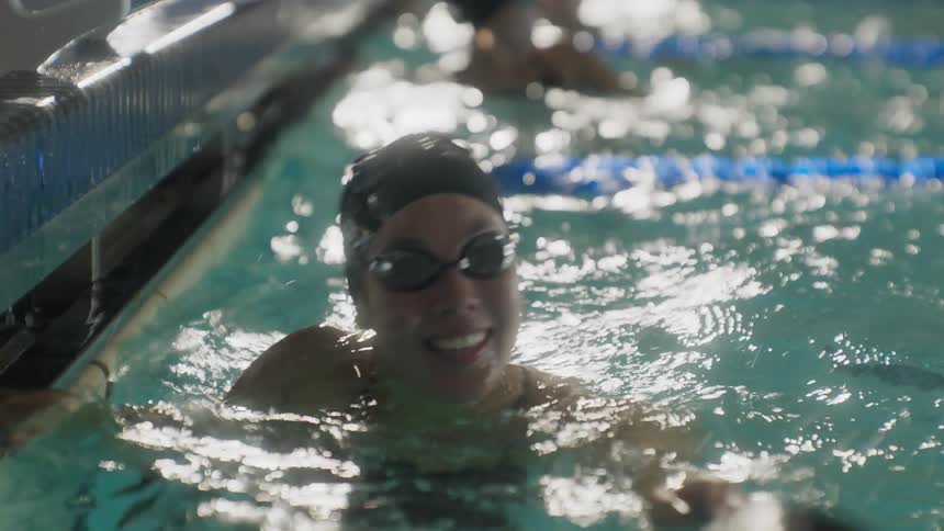 Two swimmers hug each other after finishing a race