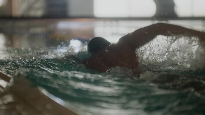 Person swimming in the pool lane taking strokes