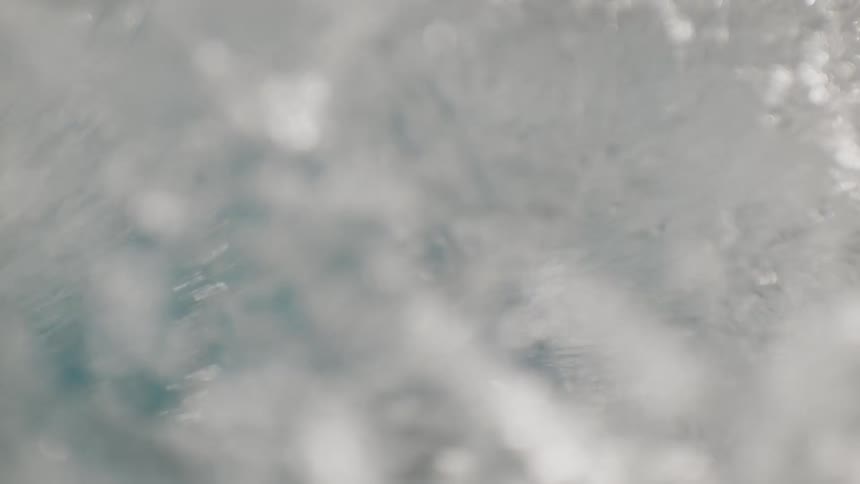 A swimmer in propels through a pool water splashing around as their arm cuts through the water