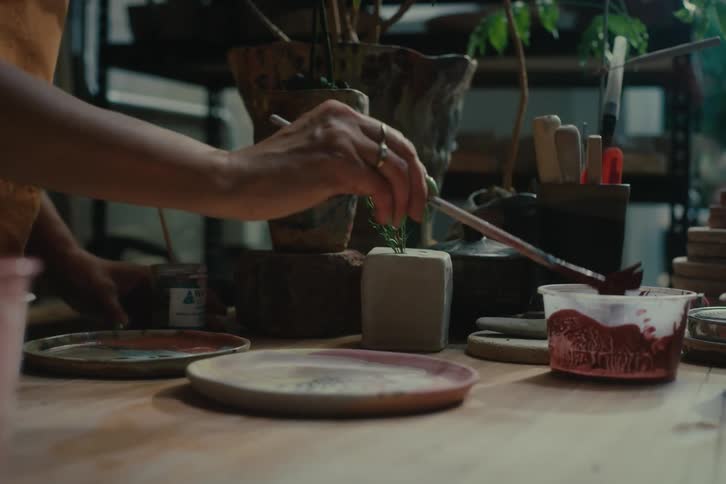 A woman puts paint on her brush