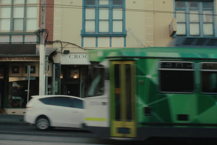 Train passing in front of a wedding dress shop next to a bakery