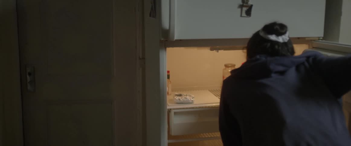 A woman looks in her fridge for food