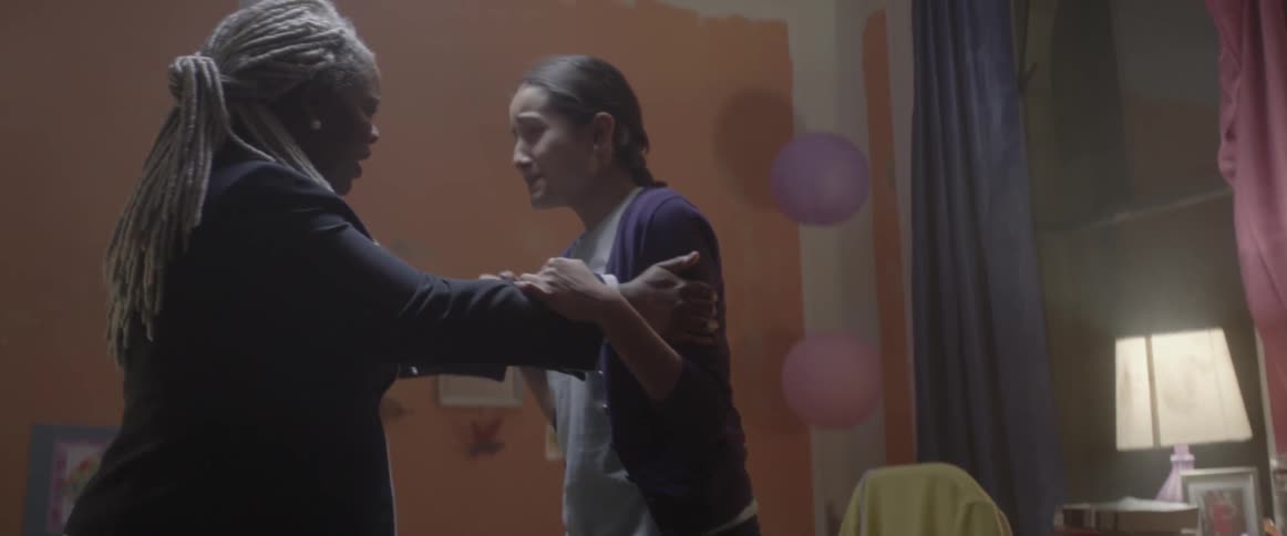 A woman grabbing a girl as she is crying and walking her away