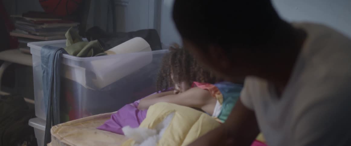A man wakes up a little girl and musses her hair