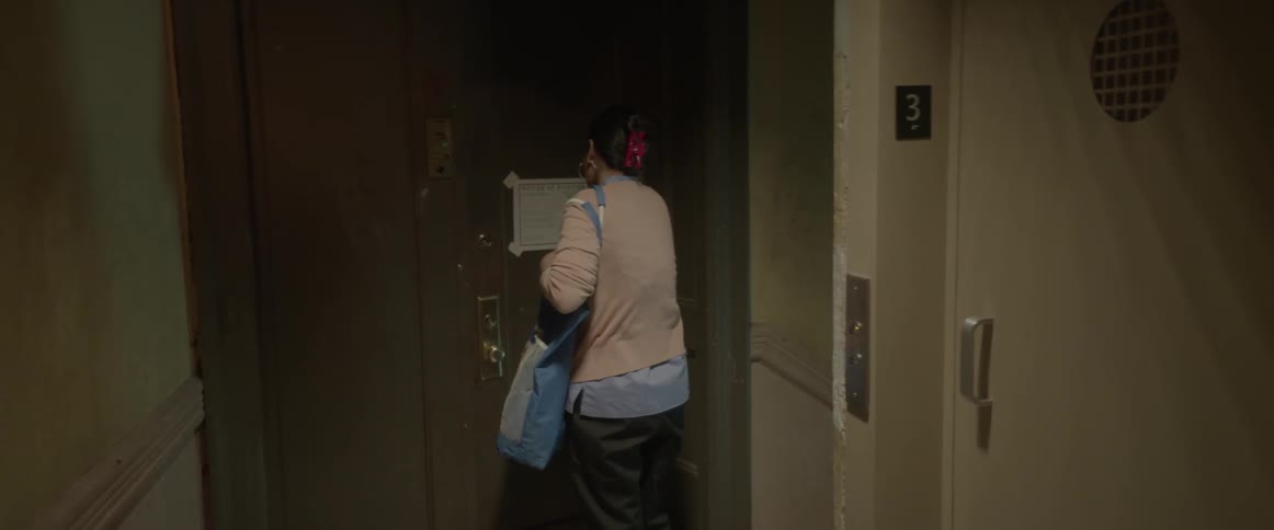A woman discovers a notice on her apartment door