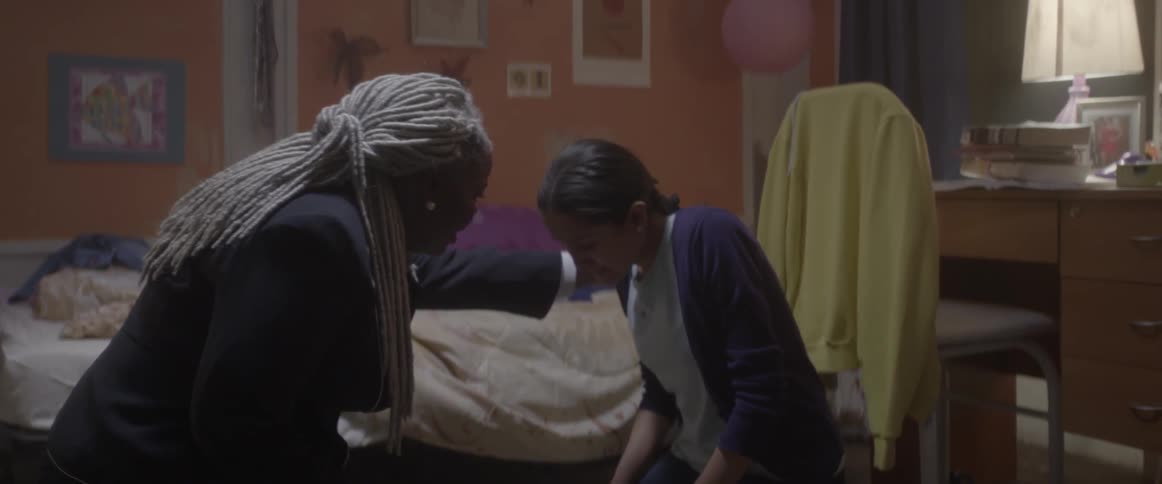 A young girl is kneeling on the floor and her mother comes to comfort her