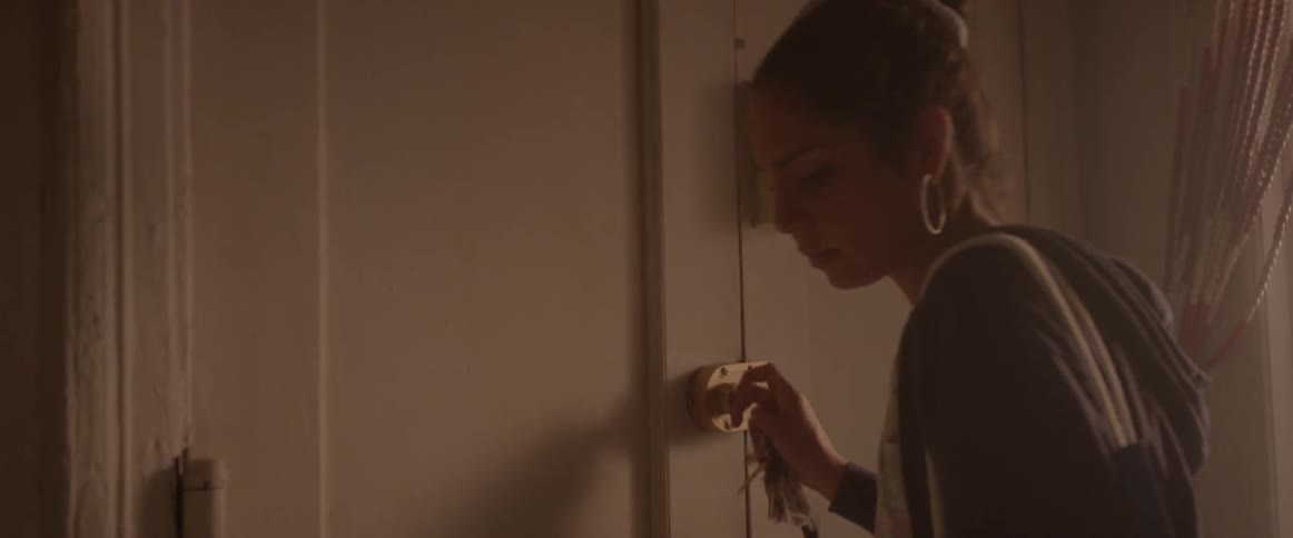 Woman securing her door with the key and then leaning against it