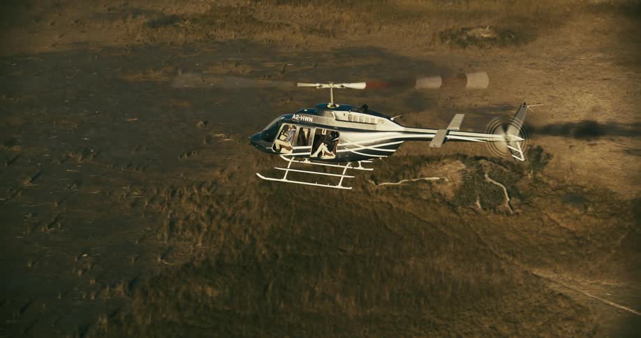A helicopter flying over a savanna