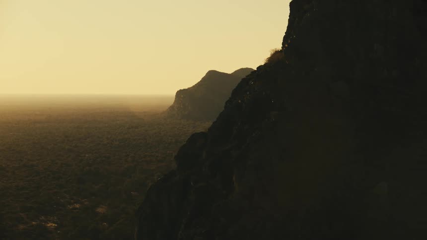A mountain range covered in haze at sunrise