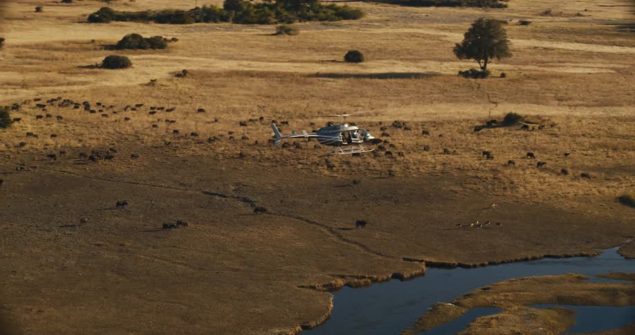A helicopter flying over a savanna