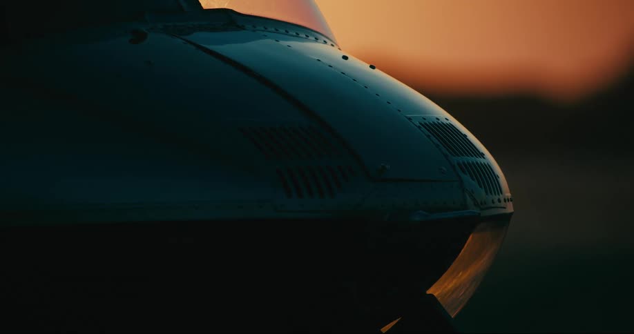 The front of a helicopter outdoors at dusk