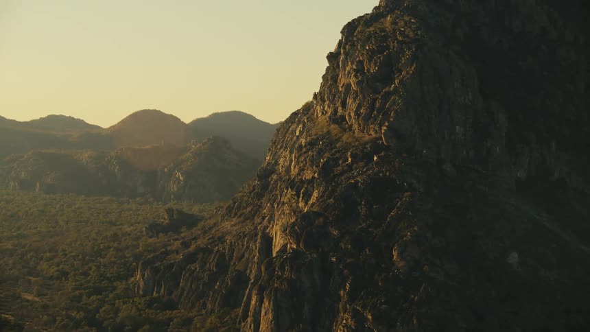 A mountain of rocks on the right side in a natural region with a clear sky