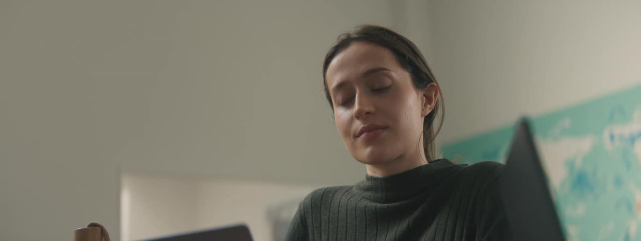 Seated woman taking off her glasses while indoors