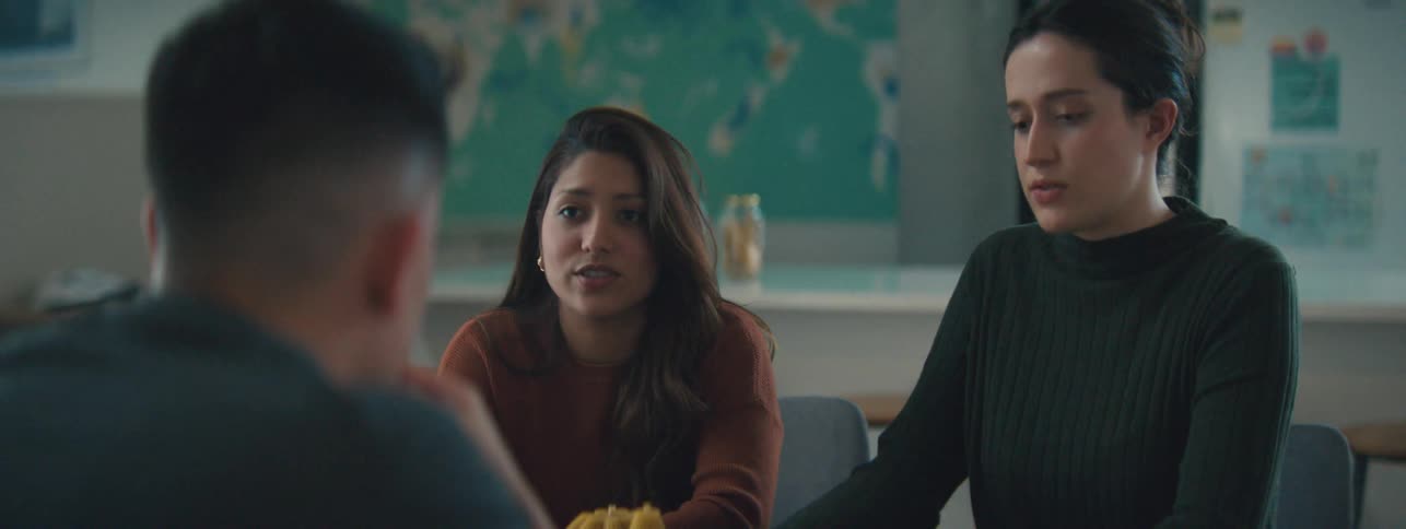 Man and two women sitting talking to each other