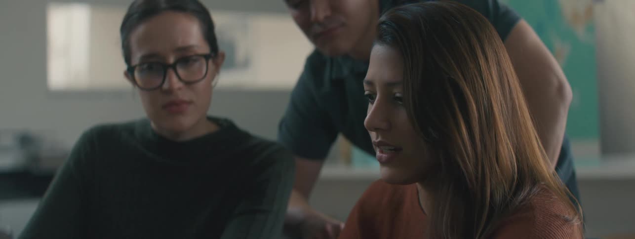 Two people are listening to a woman talk