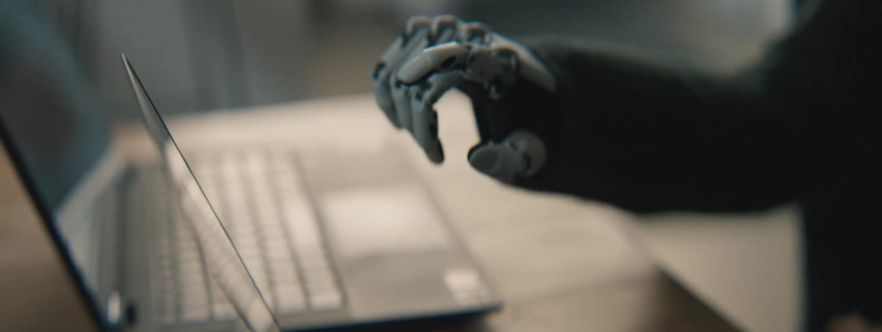 Robotic hand moving near a laptop screen