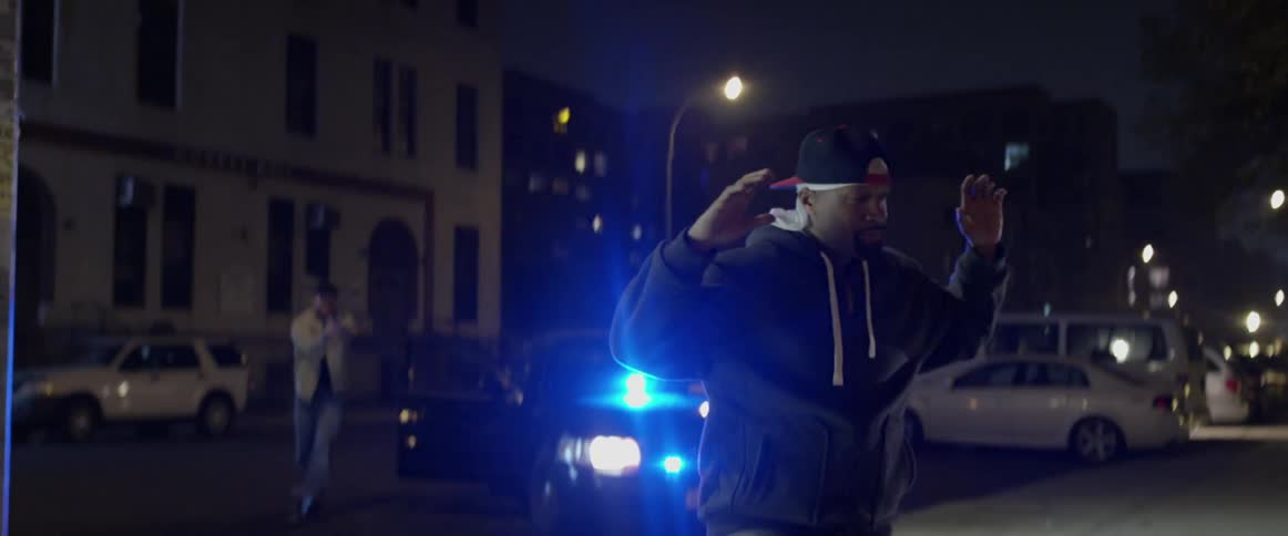 A man surrenders as police officers approach him