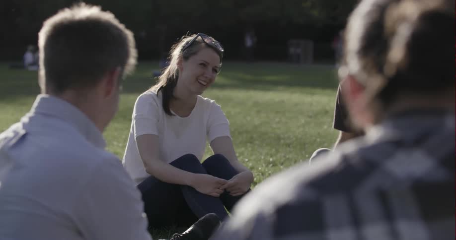 A group of people sit and laugh outside