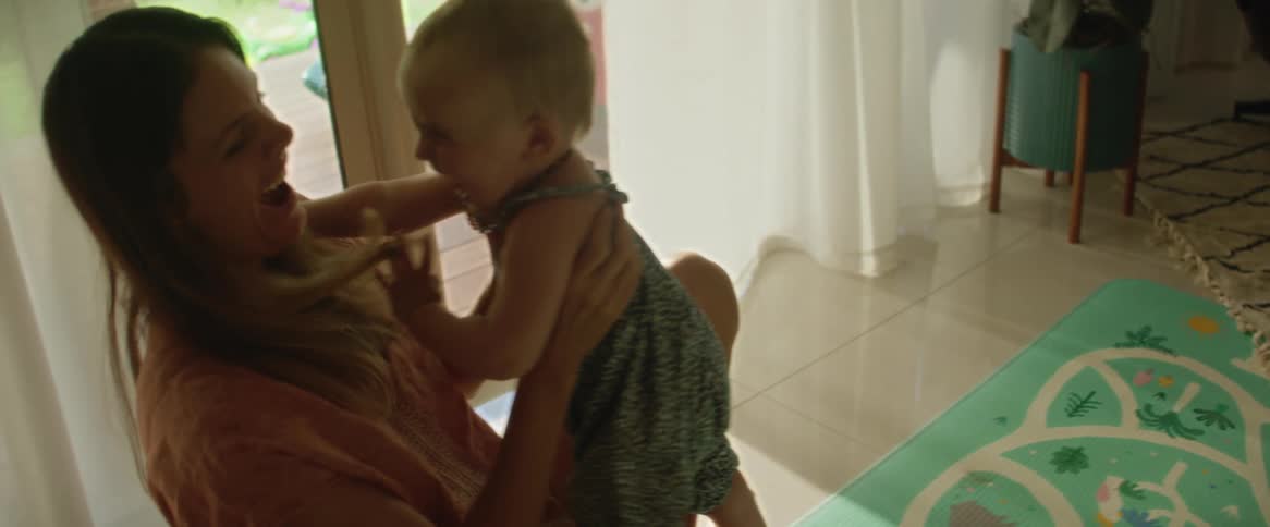 A man and a woman teach their baby how to walk