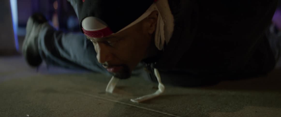 A man wearing a backwards baseball cap is laid on his chest