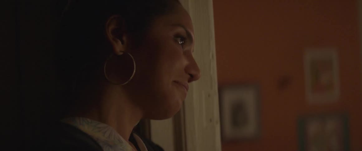 A woman is standing by a doorway looking at something