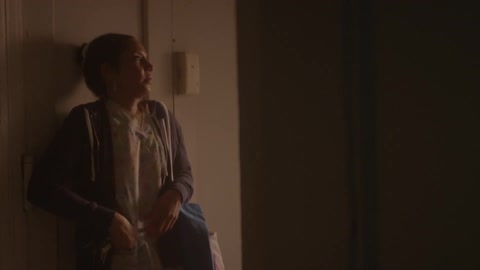 A woman walks into her apartment then shuts the door and locks it