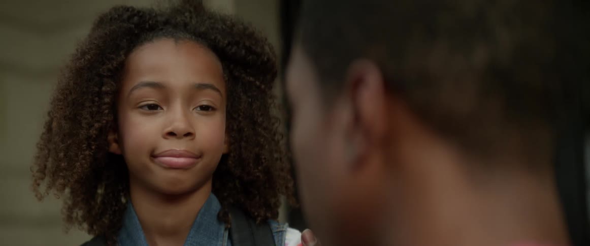 A child smiles at someone talking to her