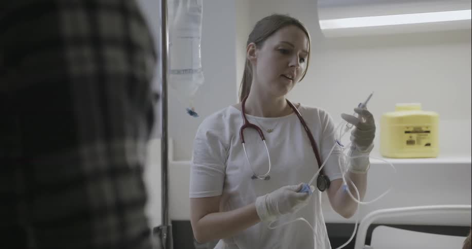 A woman is adjusting an iv tube while talking