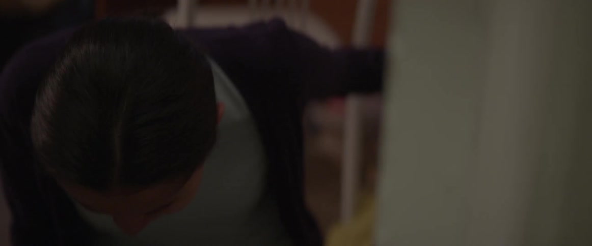 A young woman falls to the ground sobbing