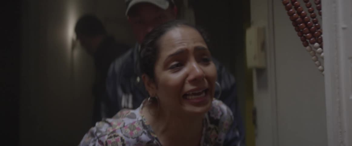 A woman is crying and talking to someone off camera as she is being arrested