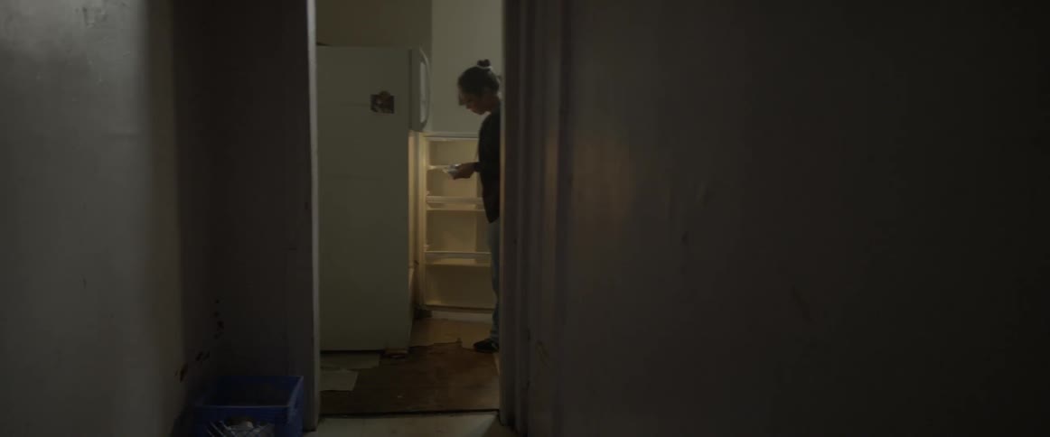 A woman grabs food from her fridge