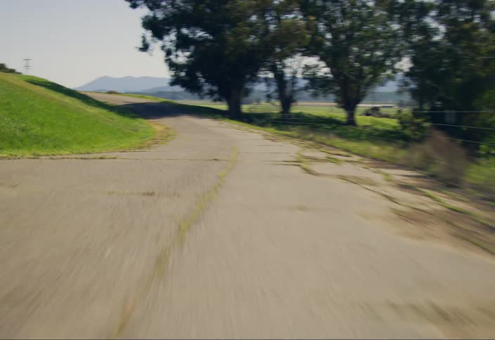 Highway passes grassy hills in the countryside on a summer day