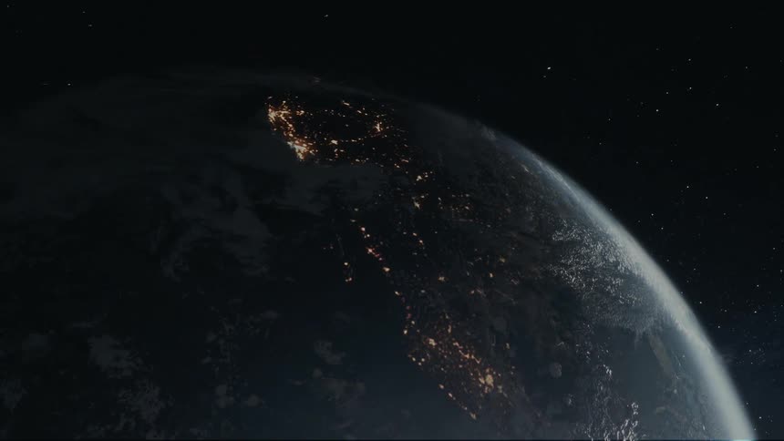 Earth seen from space at night highlighting the contrast between the dark ocean and the areas illuminated by city lights