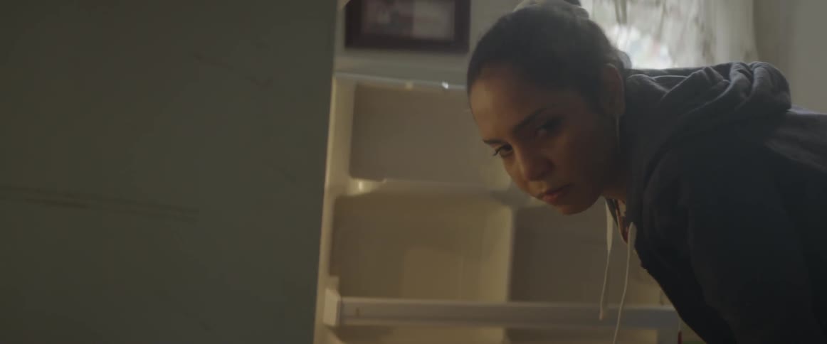 A woman searches in a refrigerator