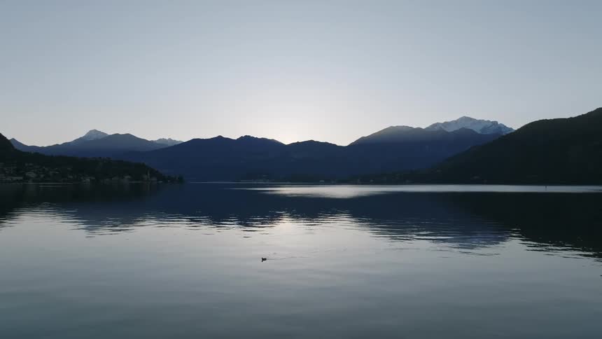 Calm lake surrounded by silhouette of mountains