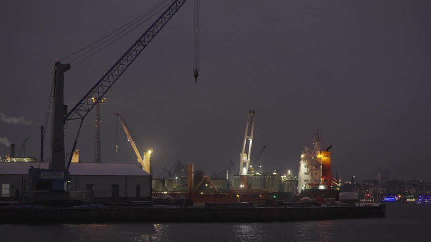Bright lights illuminate a loading dock on an overcast evening